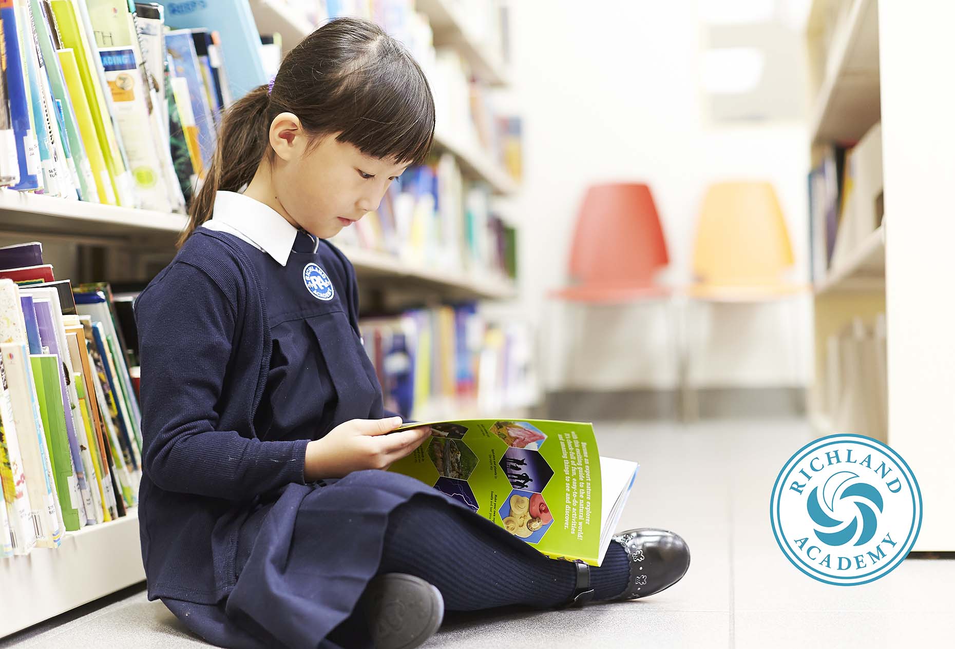 kindergarten student reading book in library